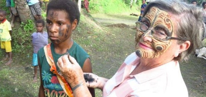Dame Carol exchanging face painting designs, Tambanum Village
